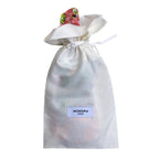 Le Flora mask in a white fabric pouch with a drawstring.