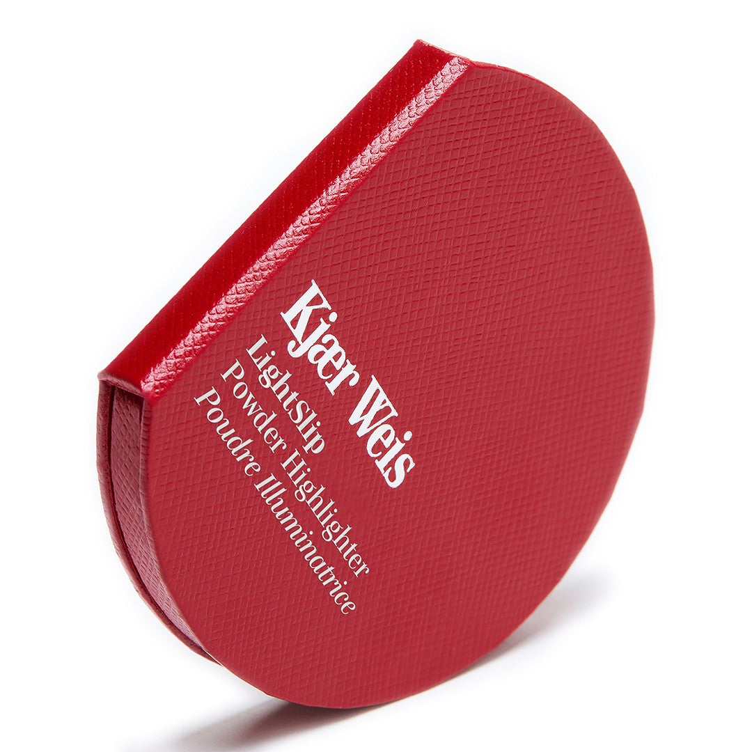 Kjaer Weis Lightslip Powder Highlighter – runde rote Dose mit strukturierter Oberfläche, weißer Hintergrund – Gesichtshighlighter