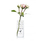 Kure Bazaar Eau Dissolvante Hydratante À La Rose – klares Glasfläschchen, rosafarbene Rosen, weißer Hintergrund – Nagelpflege