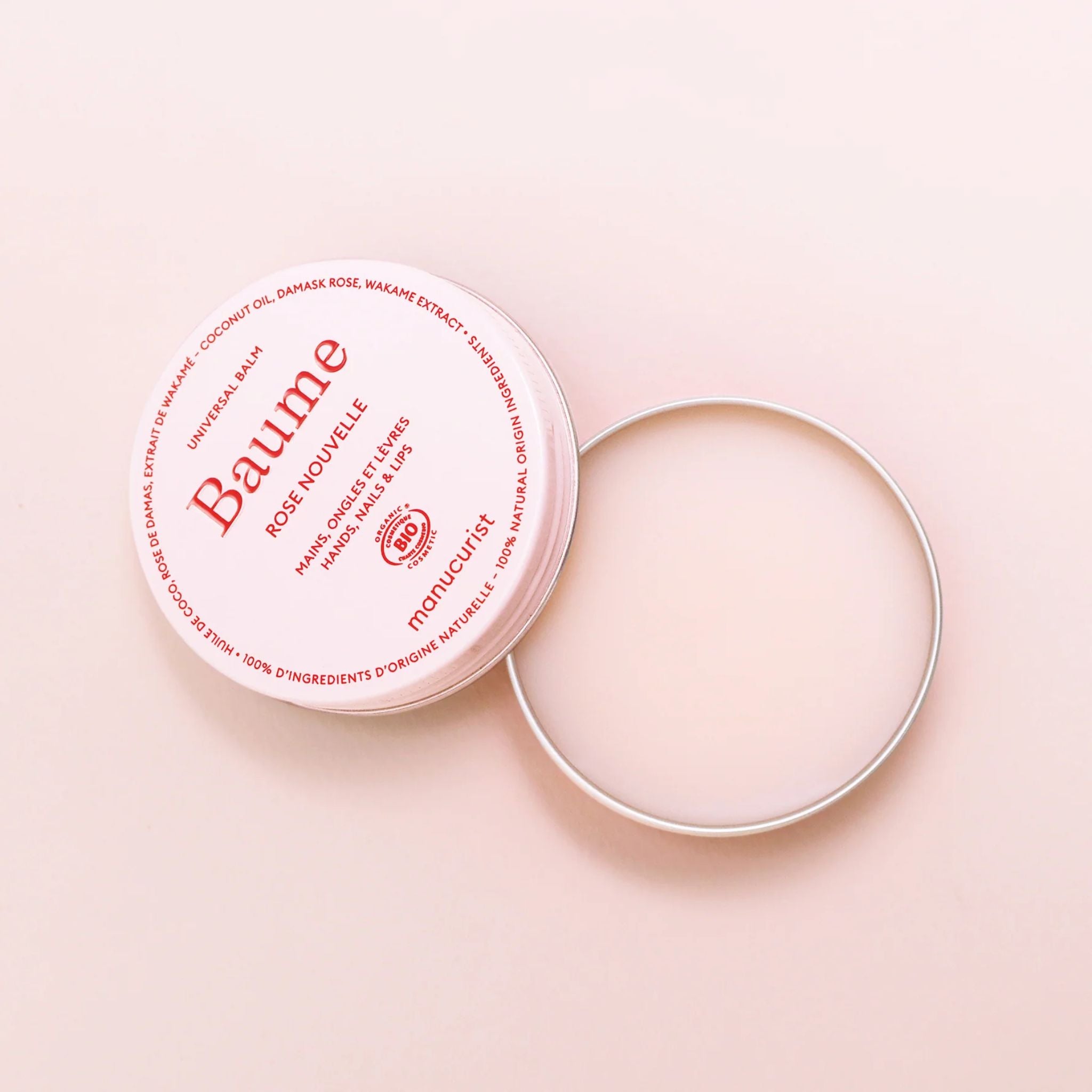 Baume Rose Nouvelle in einer rosa Dose mit geöffnetem silbernem Deckel auf rosa Hintergrund, Hautpflege