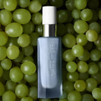 The Beautiful Night Potion – graue Flasche mit weißem Sprühkopf, grüner Trauben-Hintergrund – Hautpflege
