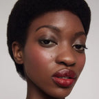 Cream Blush Happy – Model mit rosiger Wange, natürlicher Glow, weißem Hintergrund – Gesichtsmakeup
