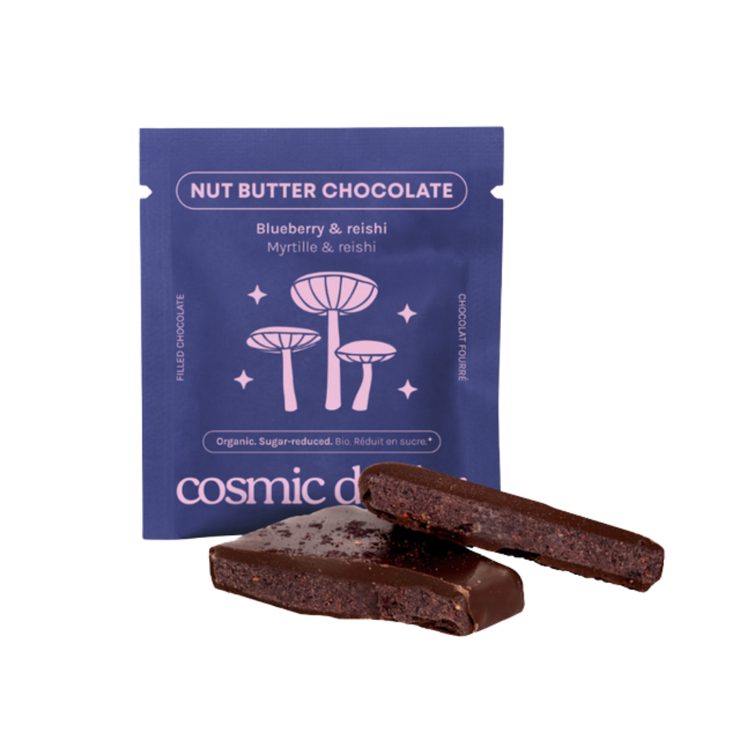 Cosmic Dust Nut Butter Chocolate Blueberry & Reishi – dunkelblaue Einzeldosisverpackung mit lila Pilzen, weißer Hintergrund