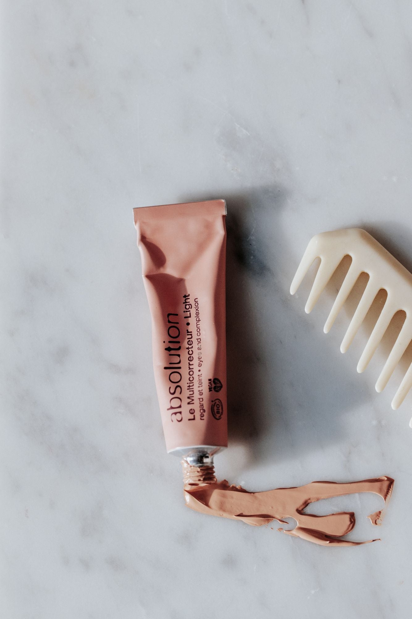 absolution Le Multicorrecteur Light – rosafarbene Tube, silberner Verschluss, Marmorhintergrund – Make-up Korrektor