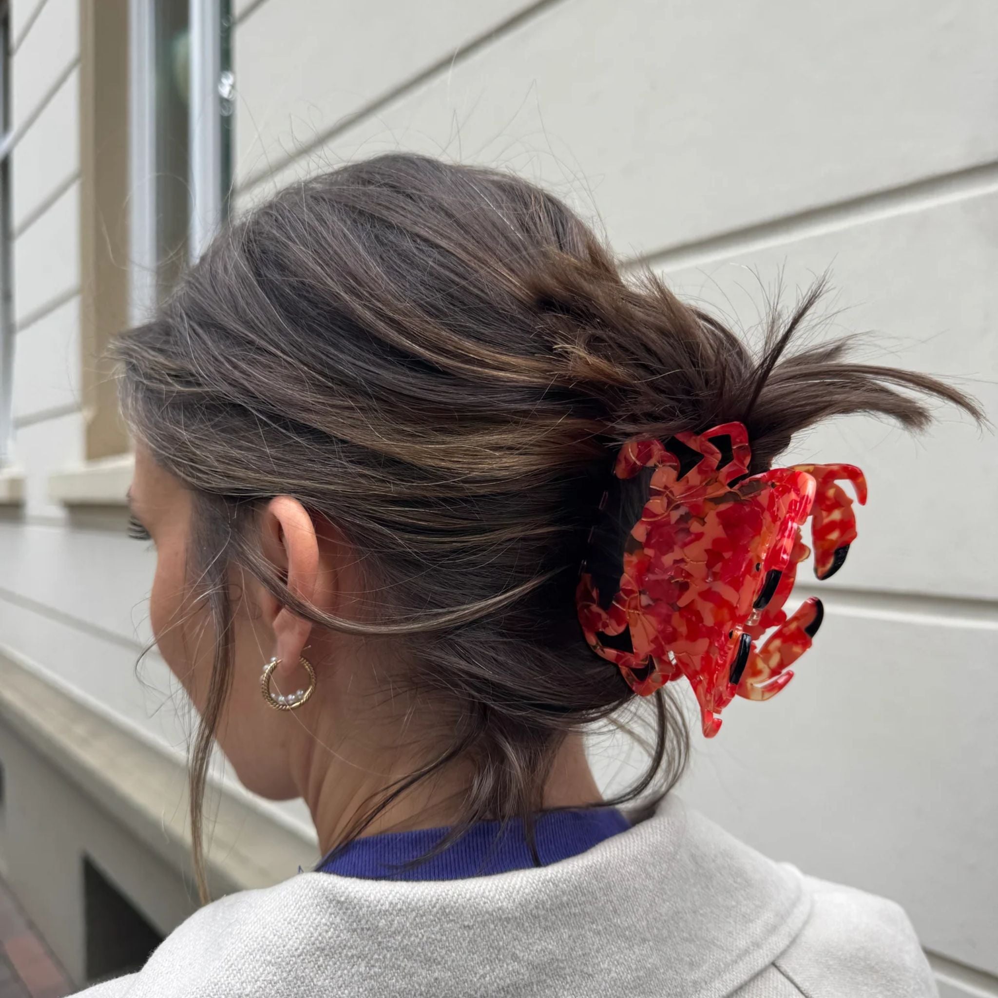 Rote marmorierte Haarklammer Krabbe im Haar einer Frau vor hellem Hintergrund, Haarstyling