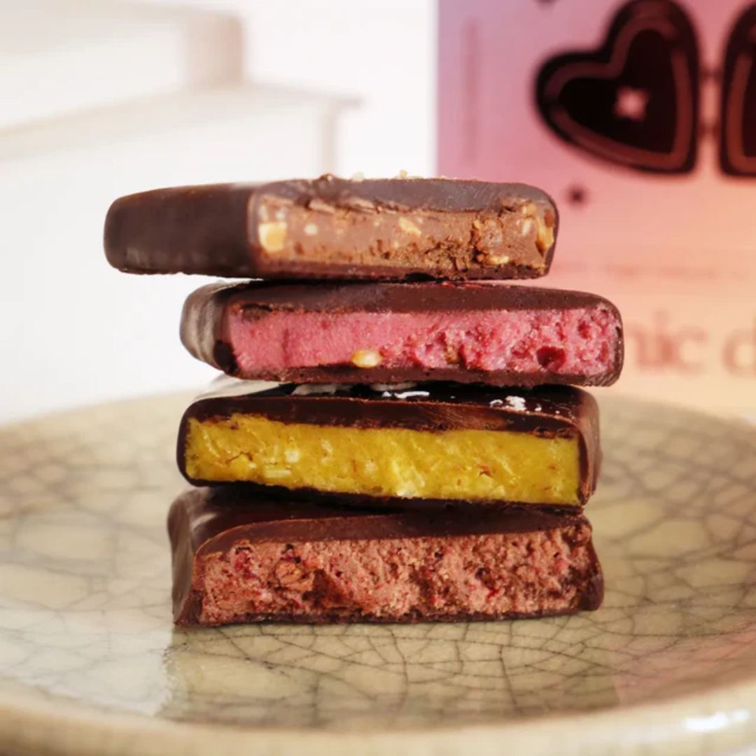 Nut Butter Chocolate – vier Geschmacksrichtungen, Schokoladenüberzug, auf Keramikteller – Snack