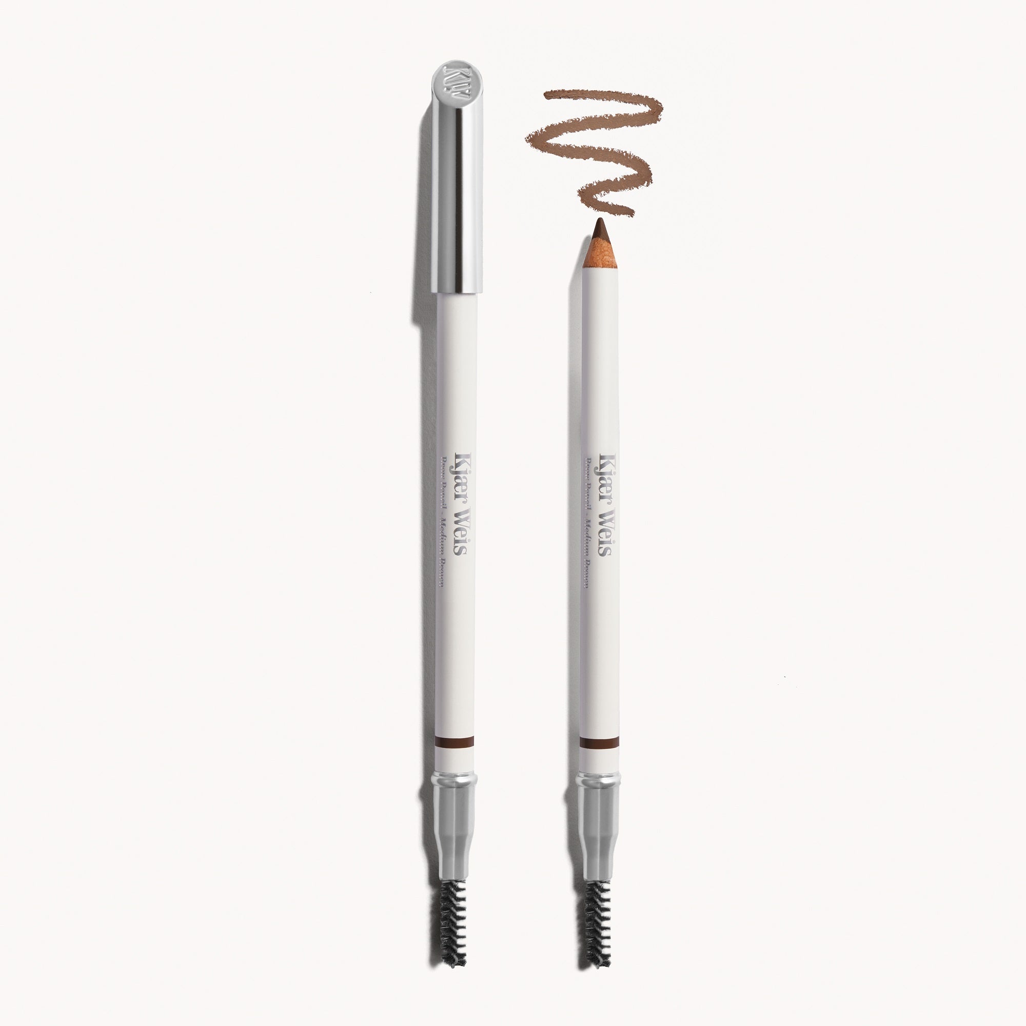 Kjaer Weis Augenbrauenstift – weißer Stift mit silbernem Deckel, Medium Brown, 11g, cremefarbener Hintergrund – Augenbrauenstyling