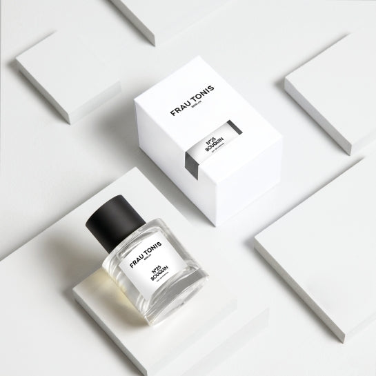 Frau Tonis N°25 Bouquin Eau de Parfum – klares Glasfläschchen mit schwarzem Deckel, weißer Verpackung, weißem Hintergrund – Parfüm