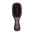 Black hairbrush with the text "Less is More" on the handle.