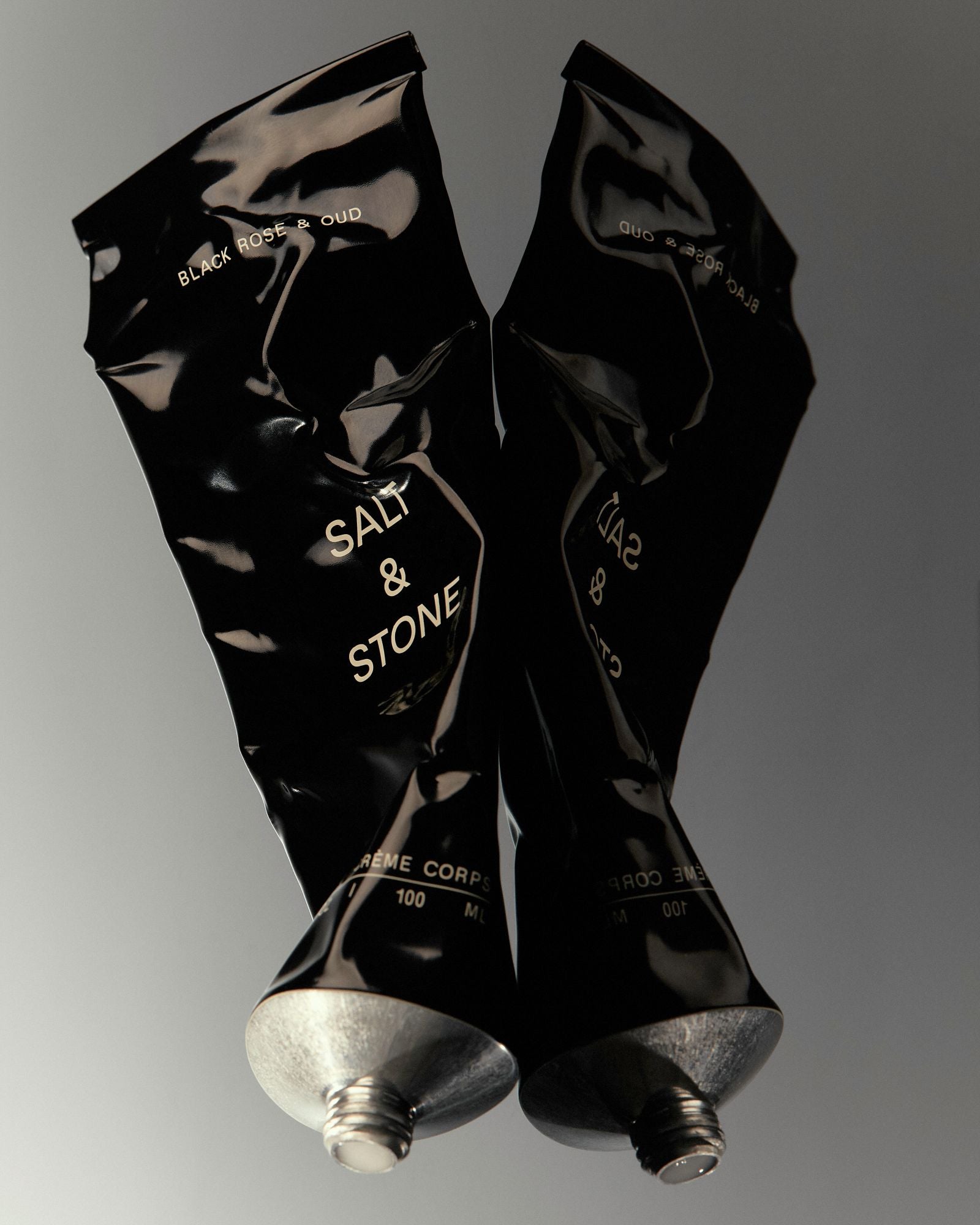 Salt & Stone Black Rose & Oud Körperlotion – schwarze Tube 100ml, silberner Verschluss, grauer Hintergrund – Hautpflege