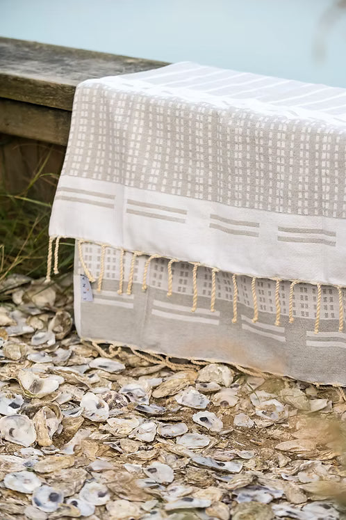 Biarritz Grey Textilprodukt in Grau und Weiß auf einem Untergrund aus Austernschalen, Strandzubehör