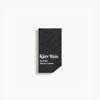 Kjaer Weis Lip Balm – black textured packaging, white background – lip care