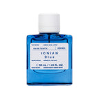 Korres Ionian Blue Eau de Toilette,  blaue Glasflasche mit weißem Verschluss auf weißem Hintergrund, Parfum