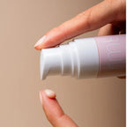 rms beauty Re" Evolve Radiance Locking Primer in einer rosa Flasche mit weißem Pumpspender für die Hautpflege.