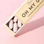 Oh My G Plant Based Chewing Gum Tropic in a beige cardboard box on a pink background, sugar-free chewing gum.