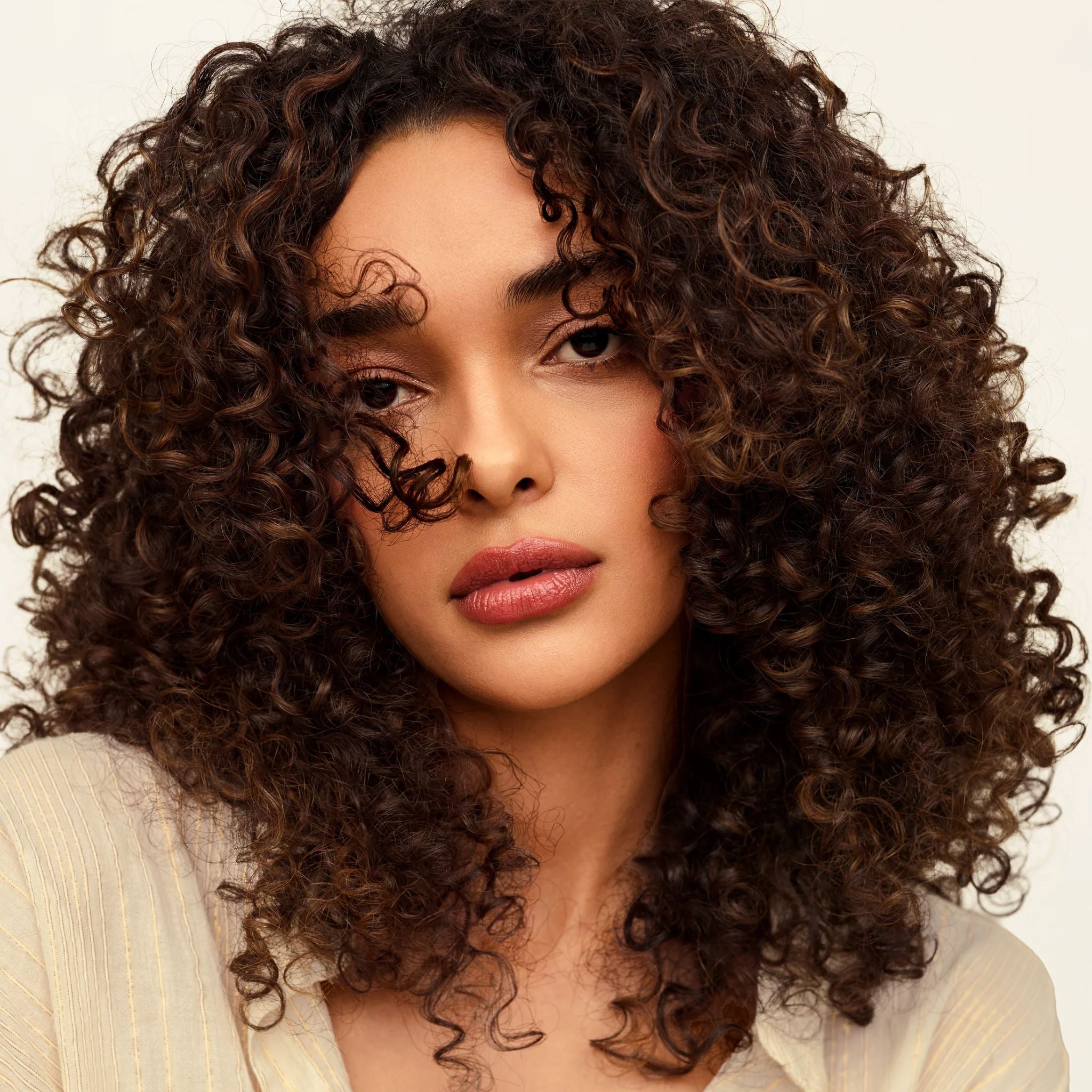 Modell mit lockigem Haar für Overnight Repair Serum Haarpflege