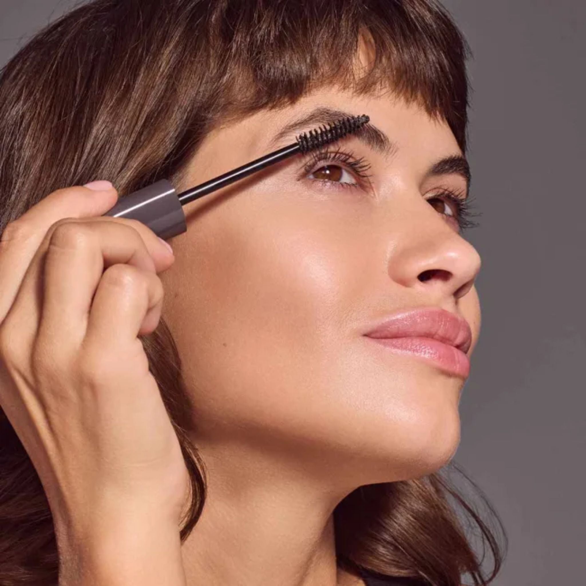 Long Lasting Mascara Limited Edition Pearl Anthracite in grauer Tube auf grauem Hintergrund, Make-up.