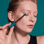 Long Lasting Mascara Limited Edition petrol mit petrolfarbenem Tube und Deckel vor grünem Hintergrund. Wimperntusche