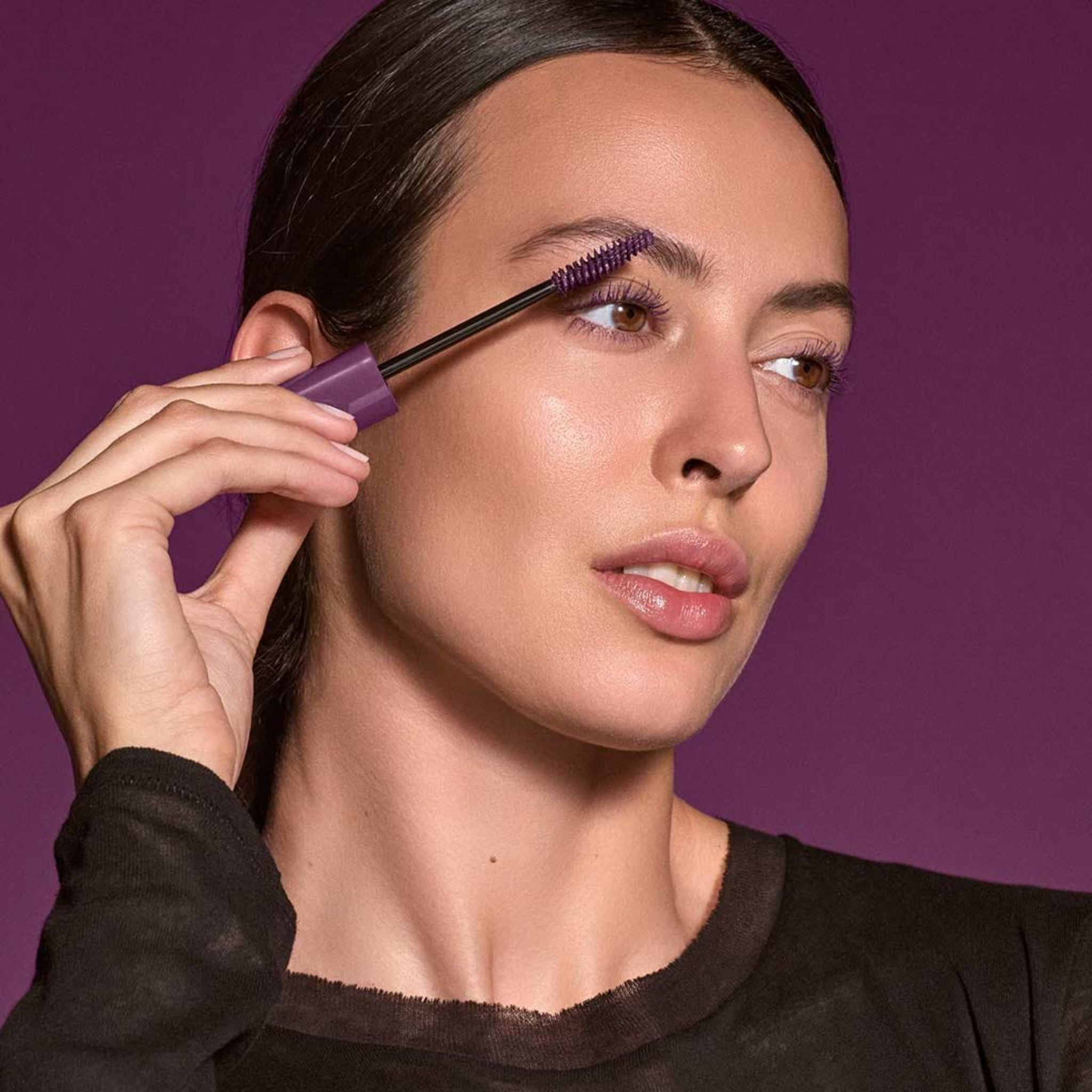Long Lasting Mascara Limited Edition Plum in einer lila Tube vor violettem Hintergrund für ein intensives Augen-Make-up.