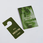 L:A Bruket No. 342 Fragrance Tag Winter Pine: a dark green fragrance tag next to its card packaging.